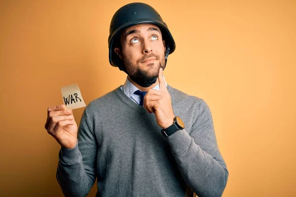 戦争のメッセージでメモ用紙を保持軍のヘルメットを身に着けているハンサムなビジネスマン質問について考える深刻な顔 非常に混乱したアイデア — ストック写真