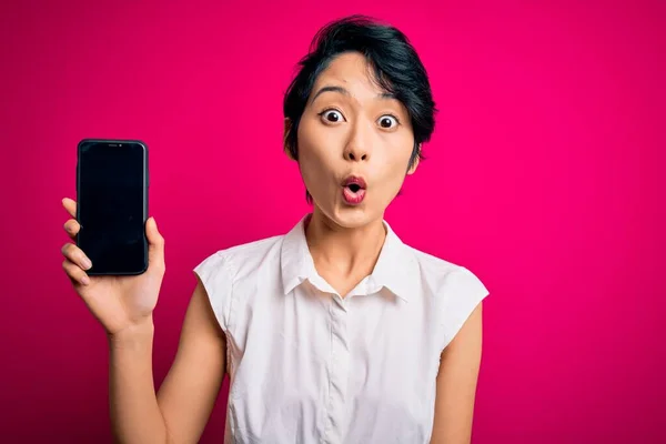 Fiatal Gyönyörű Ázsiai Lány Gazdaság Smartphone Bemutató Képernyő Felett Elszigetelt — Stock Fotó