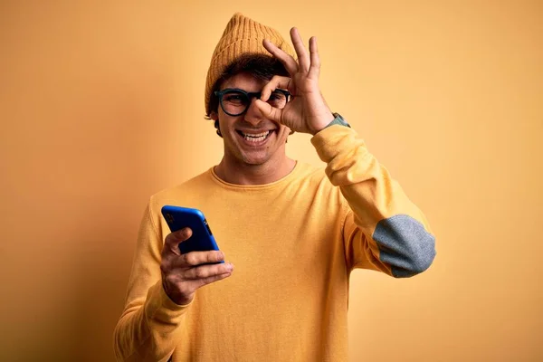 Mladý Pohledný Muž Pomocí Smartphone Nosí Brýle Přes Izolované Žluté — Stock fotografie