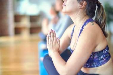 Spor salonunda yoga yapan genç ve güzel bir kadın grubu.