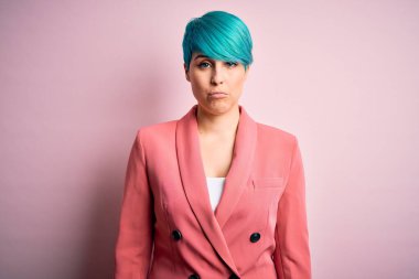 Mavi saçlı, pembe arka planda ceket giyen genç ve güzel bir iş kadını. Depresyona girmiş, üzgün ve korkmuş bir şekilde ağlıyor. Üzücü ifade.