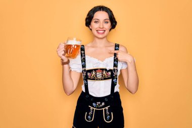 Mavi gözlü güzel Alman kadın geleneksel Ekim Festivali elbisesi giyiyor ve sürpriz yüzüyle kendini gösteren bir kavanoz bira içiyor.