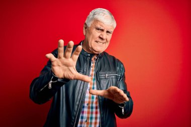 Kıdemli yakışıklı, beyaz gömlekli ve ceketli adam izole edilmiş kırmızı arka plan iğrenç yüz ifadesi, tiksindirici ve tiksindirici yüz ifadesi çünkü tiksinti tepki veriyor. Eller havada