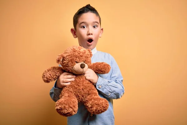 Молодий Маленький Хлопчик Обіймає Плюшевого Ведмедя Фаршированої Тварини Жовтому Тлі — стокове фото