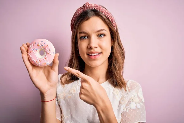 Jovem Loira Comendo Doce Padaria Açúcar Donut Sobre Rosa Isolado — Fotografia de Stock