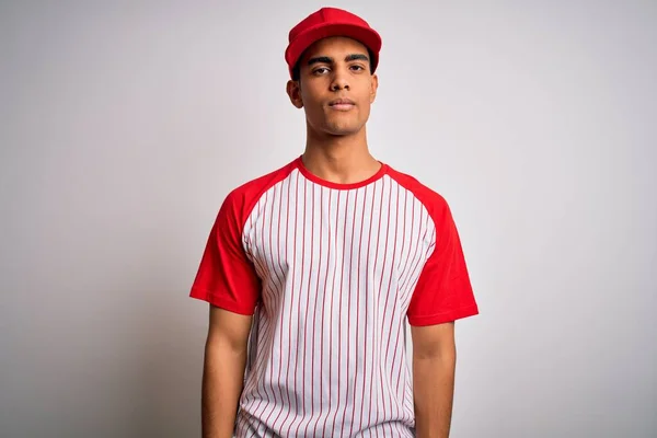 年轻英俊的非洲裔美国运动员 身穿条纹棒球T恤 头戴帽子 脸上表情严肃 简单而自然地看着相机 — 图库照片