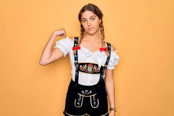 年轻美丽的金发德国女人 蓝眼睛 身穿传统的十月盛装 强壮的男人展示臂膀肌肉 自信而自豪 — 图库照片