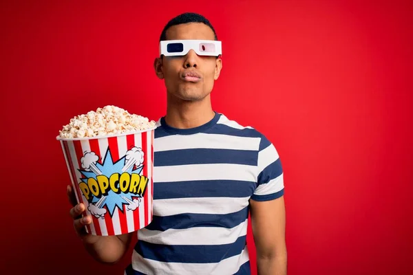 年轻英俊的非洲裔美国男人拿着3D眼镜看电影 吃着爆米花 看着摄像机 在空气中亲吻着可爱而性感 爱的表达 — 图库照片