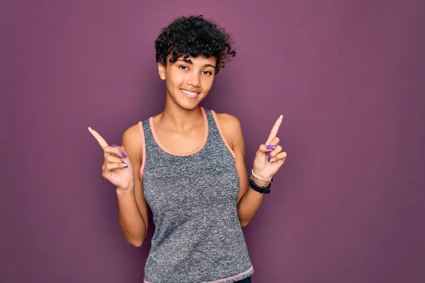 年轻美丽的非洲裔美国女运动员穿着运动服做运动 满面笑容 有信心地指指点点着不同的方向 广告的复制空间 — 图库照片