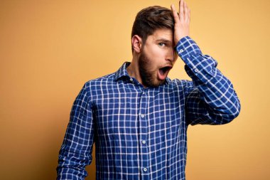 Sarışın, sakallı ve mavi gözlü, sarı arka planda tişört giyen genç bir işadamı. Hatalı olduğunu unutma. Unuttum, kötü hafıza konsepti.