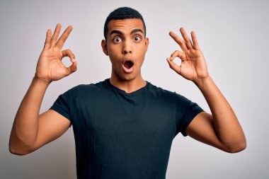 Beyaz arka planda duran sıradan tişörtler giyen genç ve yakışıklı Afro-Amerikalı adam, tamam sembolünü parmaklarıyla yaparken şaşırmış ve şok olmuştu. Çılgın ifade
