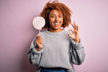 Kıvırcık saçlı, şeker yiyen güzel Afro-Amerikan kadın. Parmaklarıyla imza atıyor. Mükemmel bir sembol.