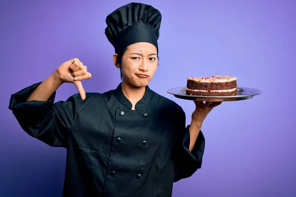 中国女厨师身穿炊事服 头戴礼帽盘 满脸怒容 不喜欢戴大拇指的负面标志 拒绝的观念 — 图库照片