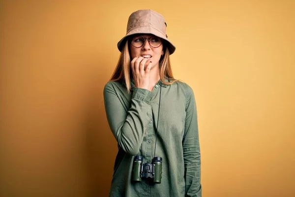 青い目をした美しいブロンドの探検家の女性は 双眼鏡を使用して帽子と眼鏡を身に着けています 不安の問題 — ストック写真