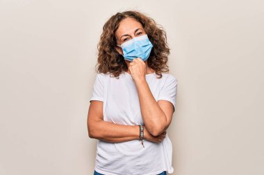 Orta yaşlı bir kadın covid-19 salgını için koronavirüs koruma maskesi takıyor kameraya kolları çapraz ve çenesi açık gülümsüyor. Olumlu düşünüyorum..