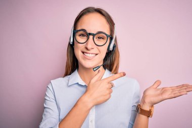 Genç, güzel çağrı merkezi ajanı, gözlüklü kadın. Kulaklıkla çalışıyor. Kameraya hayret ediyor ve gülümsüyor..
