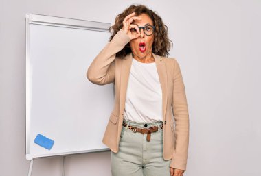 Orta yaşlı bir iş kadını. Magnetik karatahta tarafından sunulan seminer sunumunda duruyor. Şaşırmış yüz ifadesiyle şaşırmış, parmaklarından bakan gözler. İnançsız ifade.