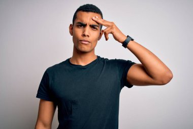 Beyaz arka planda dikilen gündelik tişörtler giyen genç ve yakışıklı Afro-Amerikan adam alnında sivilceden mutsuz, siyah noktalı çirkin bir enfeksiyon olduğunu gösteriyor. Sivilce ve deri problemi