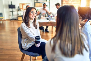 Güzel iş kadınları mutlu gülümsüyor. Gülümseyerek oturup konuşmak ofiste dinlenmek.
