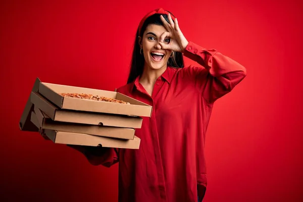 年轻美丽的黑发女子拿着装有意大利披萨的送货盒 红着脸 笑容可亲地做着手势 手牵着眼睛透过手指看 — 图库照片