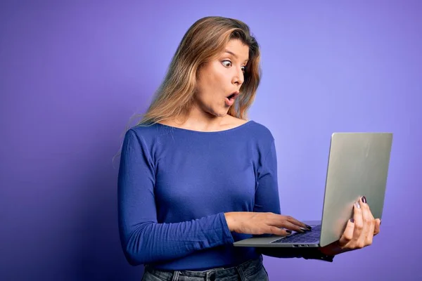 Молодая Красивая Блондинка Работает Ноутбуком Изолированном Фиолетовом Фоне Напуганная Шоке — стоковое фото