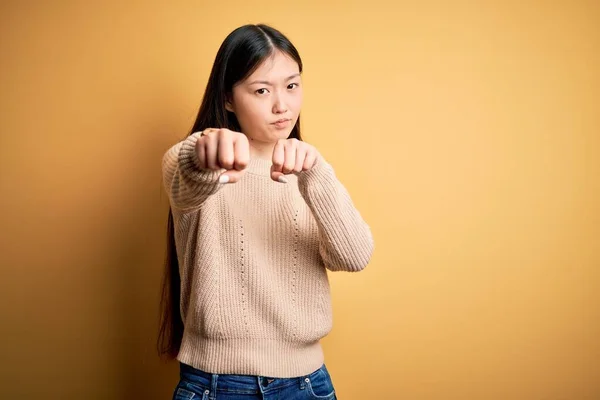 年轻美丽的亚洲女人穿着休闲装 披着黄色孤立的背景冲着拳头打斗 咄咄逼人 愤怒的攻击 威胁和暴力 — 图库照片