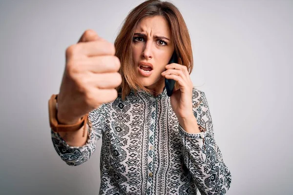 Young beautiful brunette woman having conversation talking on the smartphone annoyed and frustrated shouting with anger, crazy and yelling with raised hand, anger concept