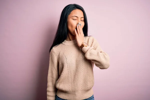 孤立したピンクの背景の上にカジュアルなセーターを着て若い美しい中国の女性は手で疲れカバー口をあくび退屈 眠れないのか — ストック写真