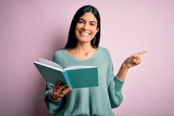 Joven Hermosa Estudiante Hispana Leyendo Libro Sobre Fondo Rosa Aislado — Foto de Stock