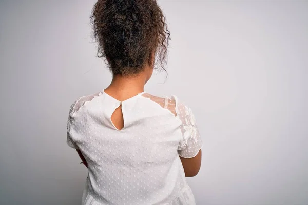 年轻美丽的非洲姑娘 身穿休闲装 站在白色的背景上 向后看去 交叉着双臂 — 图库照片