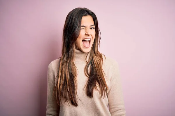 Young beautiful girl wearing casual turtleneck sweater standing over isolated pink background winking looking at the camera with sexy expression, cheerful and happy face. — Stock Image Young Beautiful Girl Wearing Casual Turtleneck Sweater Standing Isolated Pink Stock Image