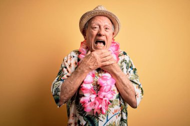 Beyaz saçlı, yaz şapkası takan ve sarı arka planda Hawaii zambağı takan yaşlı bir adam boğularak öldüğü için bağırıyor ve boğuluyor. Sağlık problemi. Boğulma ve intihar konsepti.