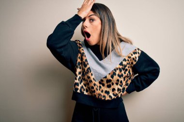 İzole edilmiş beyaz arka plan üzerinde duran sıradan bir eşofman giyen genç ve güzel bir kadın hata sonucu el ele tutuşarak şaşırdı, unutma. Unuttum, kötü hafıza konsepti.