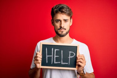 Elinde tahtayla kırmızı fırında yardım mesajı tutan genç bir adam. Akıllı yüz ifadesiyle ciddi ciddi düşünüyor.