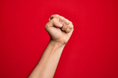 Kafkas genci parmaklarını izole edilmiş kırmızı arka planda gösteriyor protesto ve devrim hareketi yapıyor, güç ve güç gösterisi yapıyor.
