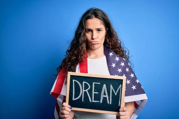 美丽的爱国女人 戴着美国国旗 拿着写着梦想信息的黑板 脸上带着自信的表情 严肃地思考着 — 图库照片