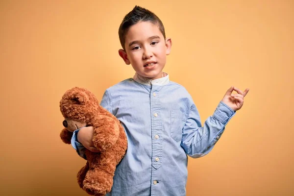 Молодий Маленький Хлопчик Який Обіймає Плюшевого Ведмедя Фаршированої Тварини Жовтому — стокове фото