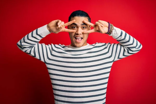 Joven Brasileño Vistiendo Casual Camiseta Rayas Pie Sobre Fondo Rojo —  Fotos de Stock