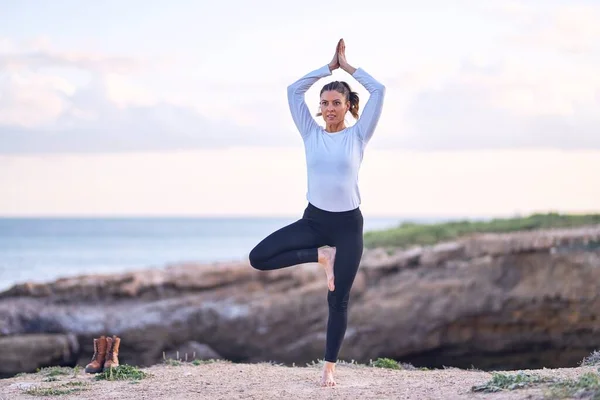 年轻美丽的女运动员练习瑜伽 教练在海滩上教树摆姿势 — 图库照片