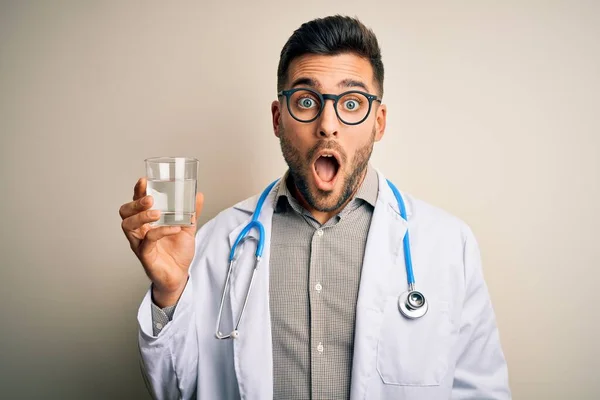 Młody Lekarz Noszący Stetoskop Pijący Świeżą Szklankę Wody Odizolowanym Tle — Zdjęcie stockowe