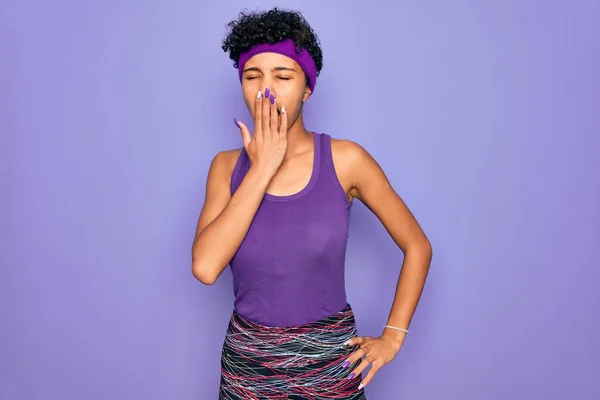 紫色の背景にカジュアルなスポーツウェアを身に着けている美しいアフリカ系アメリカ人アフロ女性は 手で口をカバー疲れYawning退屈 眠れないのか — ストック写真