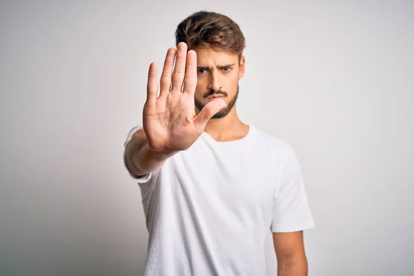 Mladý Pohledný Muž Plnovousem Neformálním Tričku Stojící Nad Bílým Pozadím — Stock fotografie