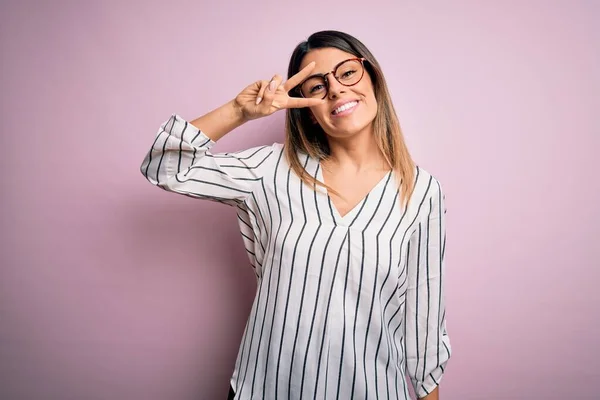 Jonge Mooie Vrouw Dragen Casual Gestreepte Shirt Bril Roze Achtergrond — Stockfoto