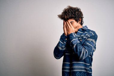 İzole edilmiş beyaz arka plan üzerinde duran sıradan tişört giyen genç yakışıklı bir adam. Ağlarken suratını ellerle kapatan üzgün bir ifade. Depresyon kavramı.