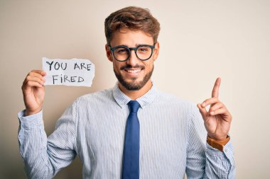 Yanında gözlük takan genç işadamı kovulur. Bir fikir ya da soru işareti ile şaşırtılır. Bir numara: