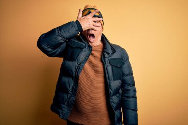 Orta yaşlı, yakışıklı, gri saçlı, tatilde kayakçı. Kayak gözlüğü takıyor. Yüzü ve gözleri kapalı, utangaç bir ifadeyle parmaklarından bakıyor..