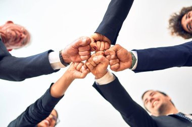 Bir grup iş adamı mutlu ve kendinden emin gülümsüyor. Ofiste yüzünde gülümseme ve yumruklarla bir çemberin üzerinde durmak..