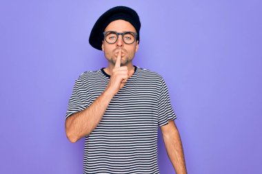 Mor arka planda mavi gözlü, çizgili tişört ve Fransız beresi giyen yakışıklı bir adam sessiz olmak istiyor. Sessizlik ve gizli konsept.