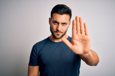 Sıradan tişörtler giyen genç yakışıklı adam izole edilmiş beyaz arka planda durup avucunun içi gibi şarkı söylemeyi kesiyor. Yüzünde olumsuz ve ciddi bir jest olan uyarı ifadesi.