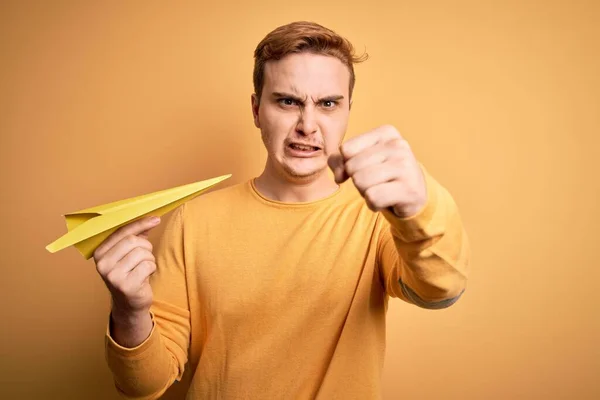 Joven Hombre Pelirrojo Guapo Sosteniendo Avión Papel Sobre Fondo Amarillo —  Fotos de Stock